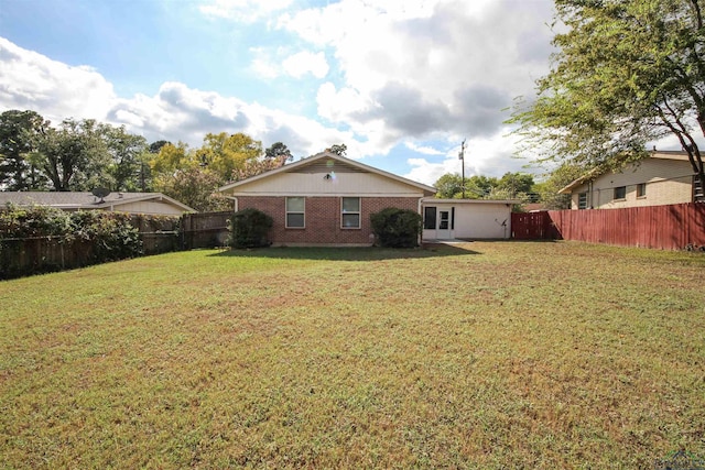 rear view of property with a yard