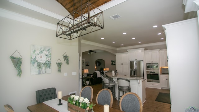 dining area with crown molding, ceiling fan, and dark wood-type flooring