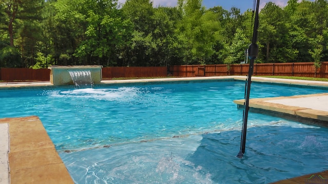 view of swimming pool with pool water feature