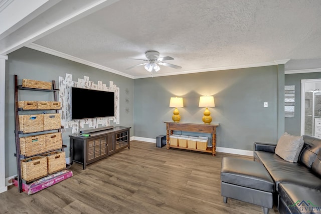 living room featuring baseboards, wood finished floors, ceiling fan, and a textured ceiling