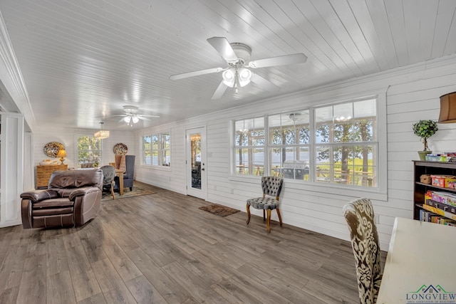 living area featuring wood ceiling, ceiling fan, wood finished floors, and ornamental molding