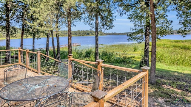 wooden deck with outdoor dining space and a water view