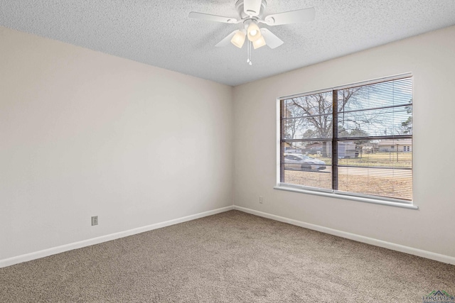 unfurnished room featuring a textured ceiling, carpet floors, ceiling fan, and baseboards