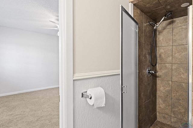 full bathroom with a shower stall and baseboards