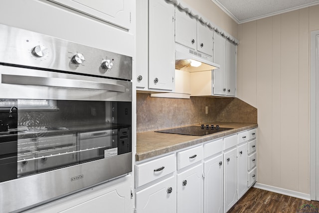 kitchen featuring white cabinets, under cabinet range hood, and black electric cooktop