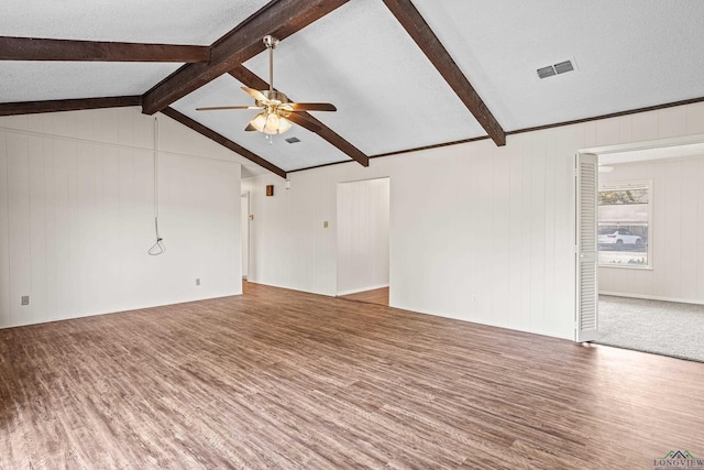 unfurnished living room featuring a textured ceiling, lofted ceiling with beams, wood finished floors, visible vents, and a ceiling fan