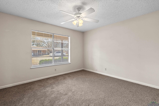 carpeted spare room with baseboards, a ceiling fan, and a textured ceiling