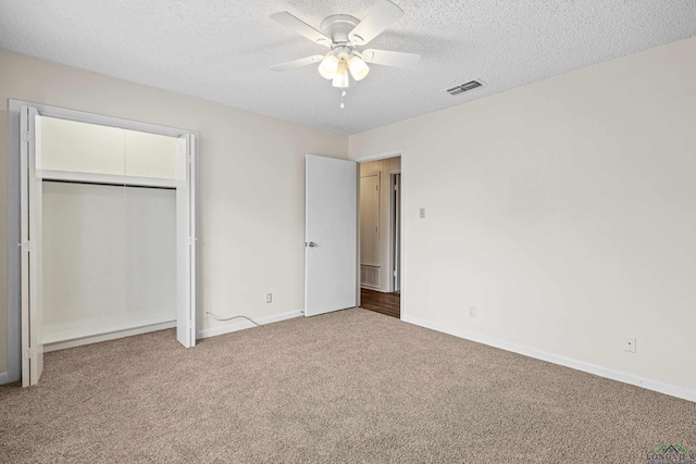 unfurnished bedroom with baseboards, visible vents, a textured ceiling, and carpet flooring