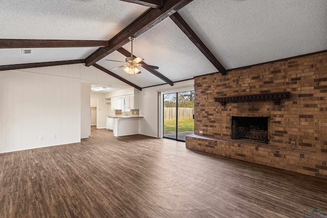 unfurnished living room featuring dark wood-style floors, a brick fireplace, and a textured ceiling