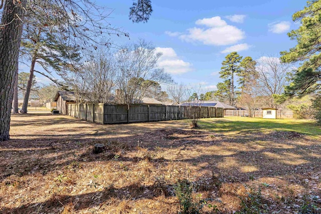 view of yard featuring an outbuilding, fence, and a storage unit