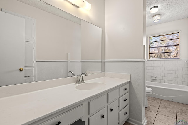 bathroom featuring a textured ceiling, vanity, tile patterned flooring, and toilet