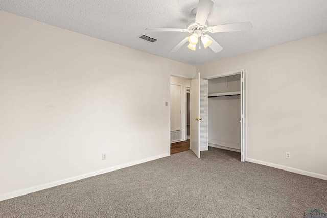 unfurnished bedroom featuring carpet floors, baseboards, visible vents, and a textured ceiling