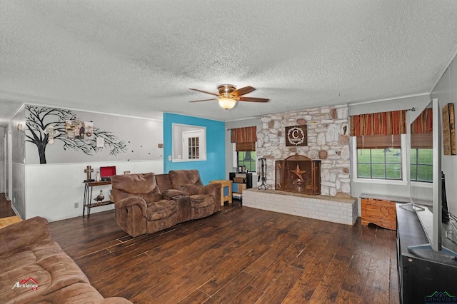 living room with a textured ceiling, a stone fireplace, ceiling fan, and dark hardwood / wood-style floors