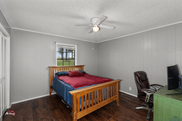 bedroom with a closet, dark hardwood / wood-style floors, ceiling fan, and ornamental molding