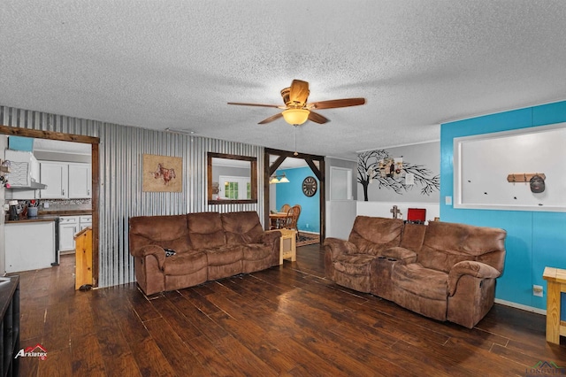 living room with a textured ceiling, dark hardwood / wood-style flooring, and ceiling fan