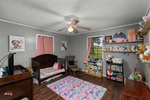 bedroom with ceiling fan, dark hardwood / wood-style flooring, ornamental molding, and a textured ceiling