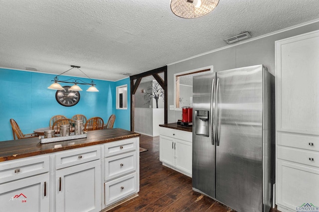 kitchen with wooden counters, stainless steel fridge with ice dispenser, white cabinets, and hanging light fixtures