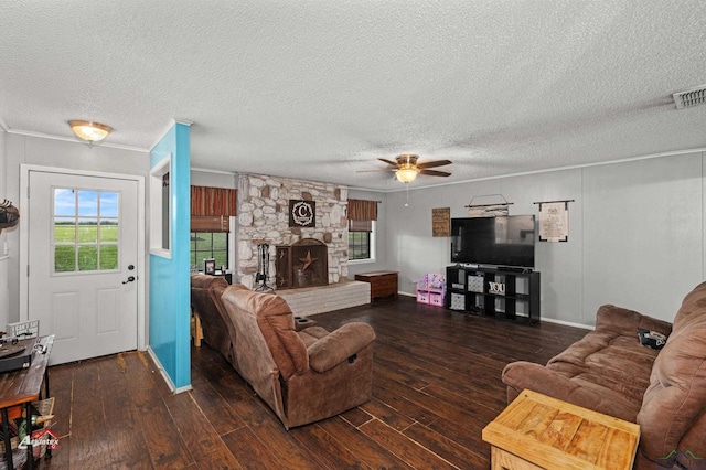 living room featuring a textured ceiling, ceiling fan, a fireplace, and dark hardwood / wood-style floors