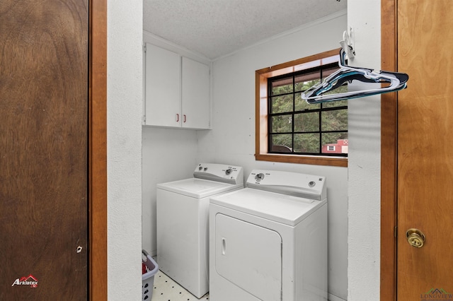 laundry area with washer and dryer, cabinets, and a textured ceiling