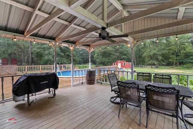 deck with a fenced in pool, ceiling fan, and a grill