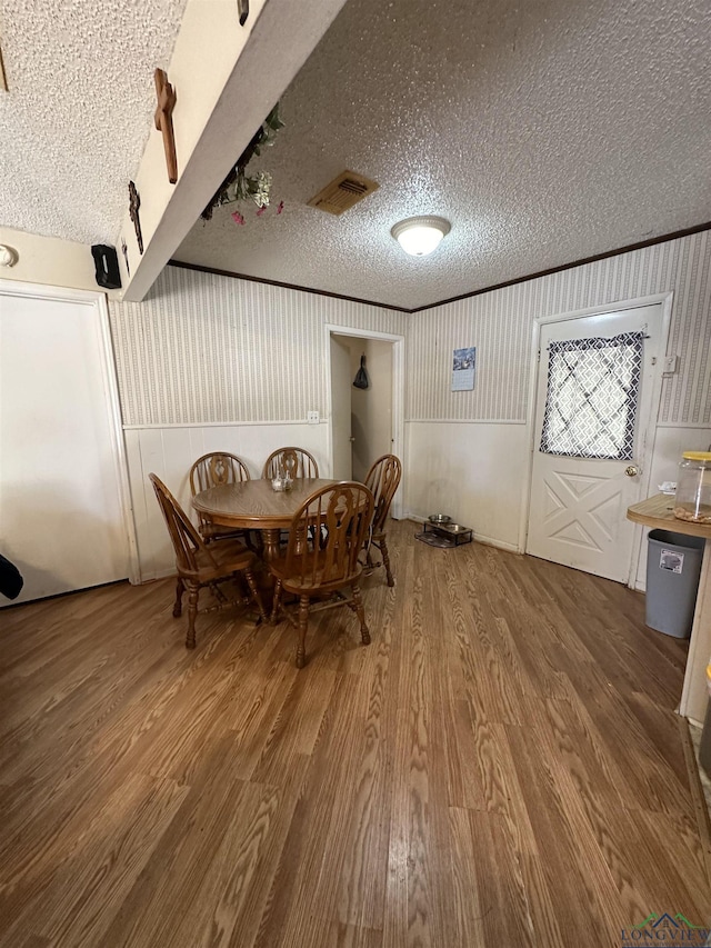 18335 Fm 1716 E, Tatum, TX 75691 - dining area with hardwood / wood-style floors, crown molding, and a textured ceiling