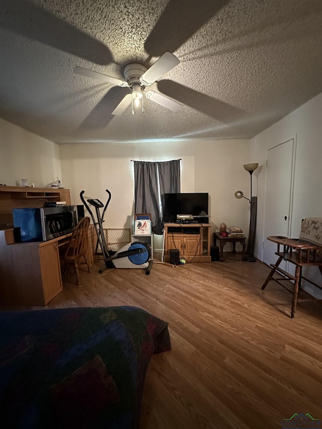 18335 Fm 1716 E, Tatum, TX 75691 - bedroom with ceiling fan, hardwood / wood-style floors, and a textured ceiling