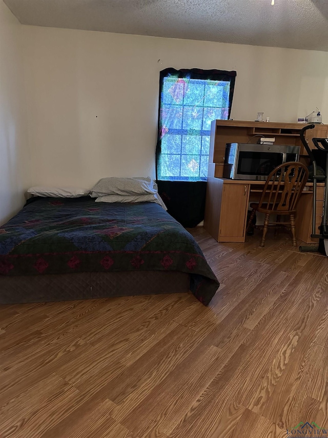 18335 Fm 1716 E, Tatum, TX 75691 - bedroom with hardwood / wood-style floors and a textured ceiling