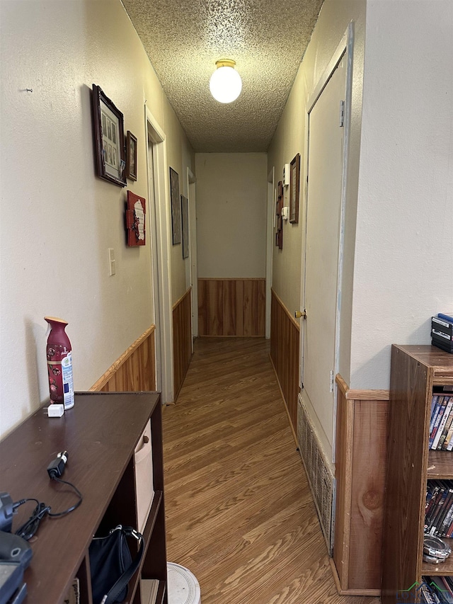 18335 Fm 1716 E, Tatum, TX 75691 - hall with wood-type flooring, a textured ceiling, and wood walls