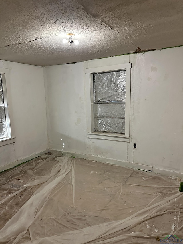 unfurnished room with a textured ceiling