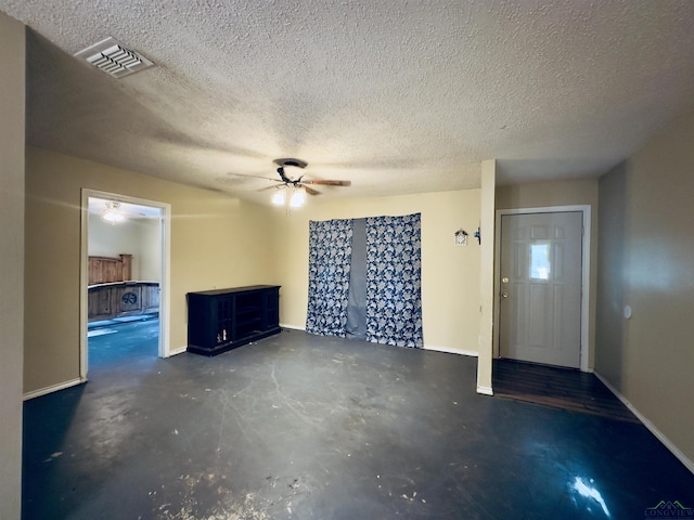 unfurnished living room with a textured ceiling and ceiling fan