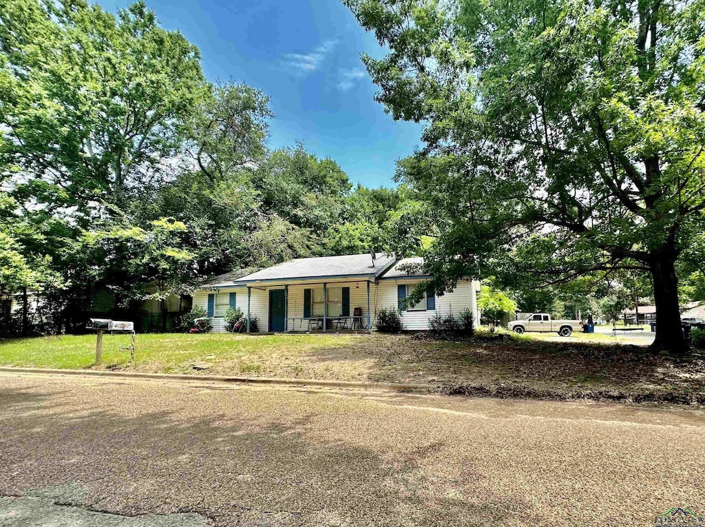 ranch-style house with a porch and a front yard