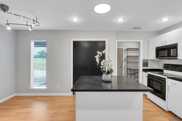 kitchen with light wood-type flooring, electric range, white cabinetry, and a kitchen island