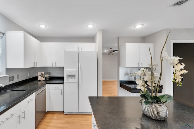 kitchen featuring white cabinetry and white fridge with ice dispenser