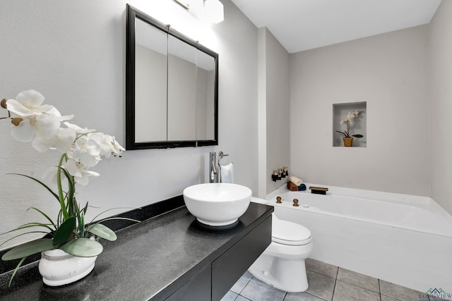 bathroom with tile patterned floors, vanity, toilet, and a bath