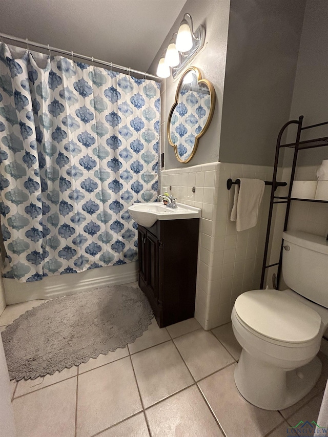 bathroom with tile patterned floors, toilet, vanity, tile walls, and a shower with shower curtain