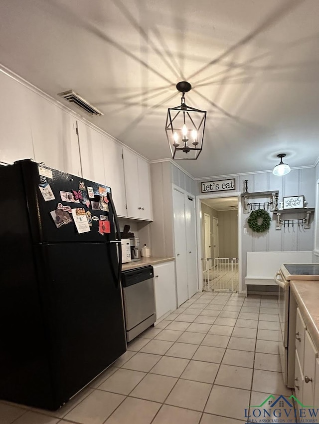 kitchen featuring electric range oven, stainless steel dishwasher, pendant lighting, black refrigerator, and white cabinets