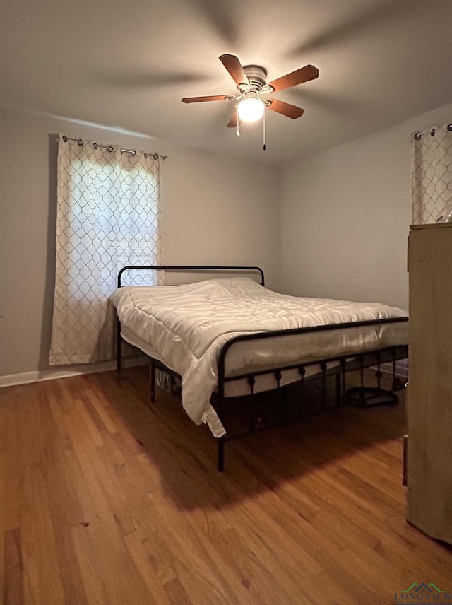 bedroom featuring wood-type flooring and ceiling fan