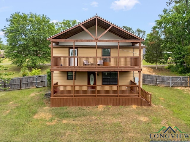 back of property with a yard, a wooden deck, and a fenced backyard