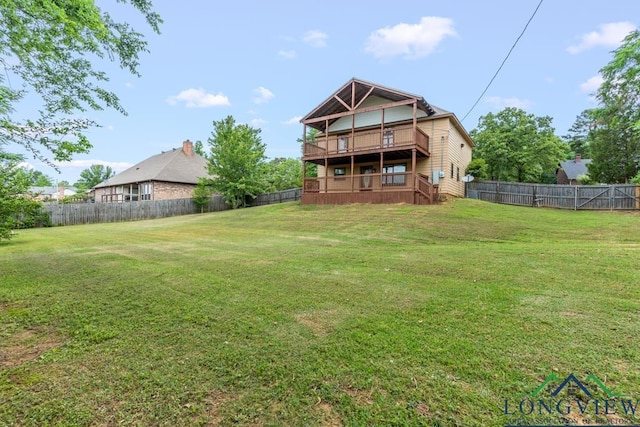 rear view of house featuring a fenced backyard and a lawn