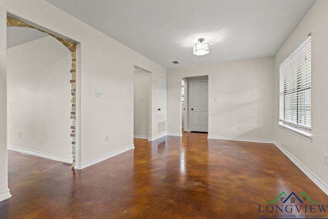 unfurnished room with baseboards, visible vents, and concrete floors