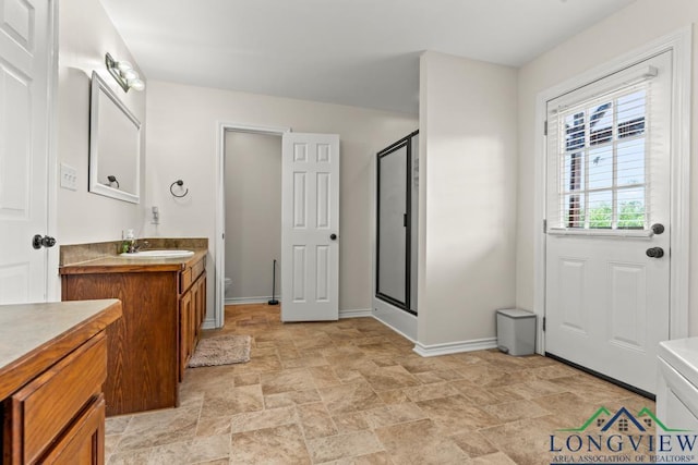 full bath featuring vanity, baseboards, stone finish floor, and a stall shower