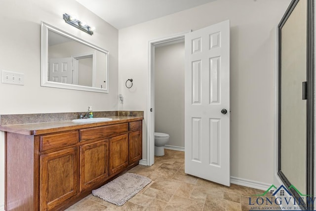 full bath with toilet, baseboards, and vanity