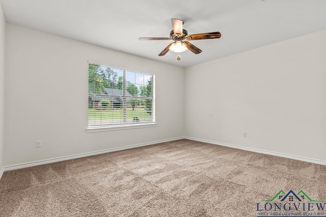 carpeted spare room with baseboards and a ceiling fan