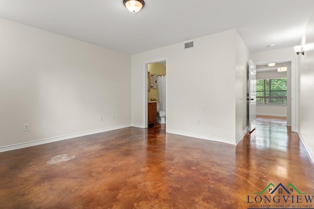 unfurnished room featuring finished concrete floors, baseboards, and visible vents