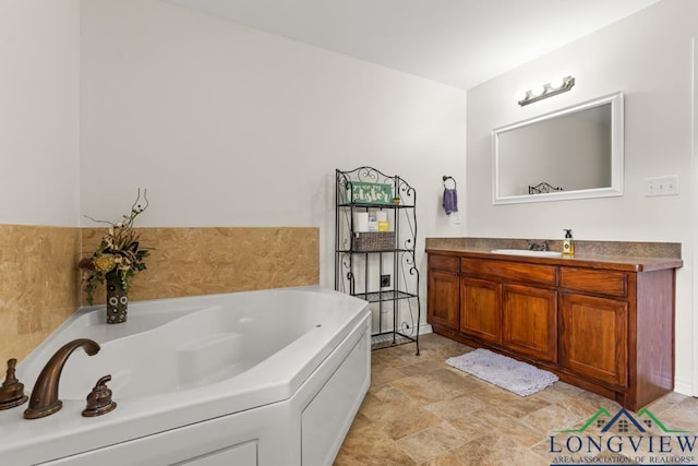 bathroom with vanity, a garden tub, and stone finish flooring