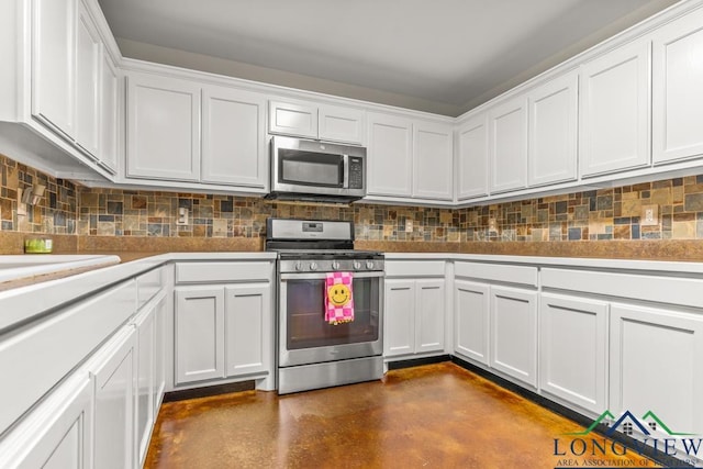 kitchen featuring white cabinets, stainless steel appliances, tasteful backsplash, and finished concrete flooring