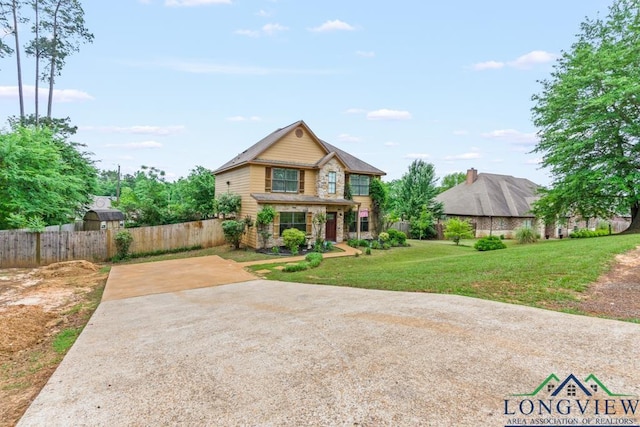 craftsman inspired home featuring a front lawn, fence, and concrete driveway