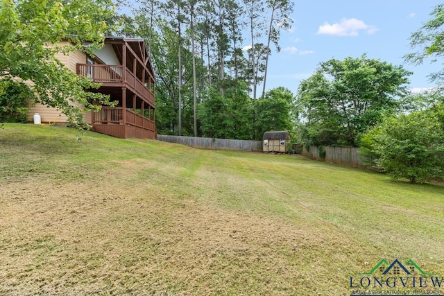 view of yard featuring fence, an outbuilding, and a shed