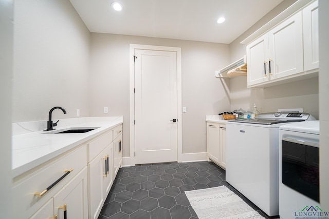 clothes washing area with sink, dark tile patterned floors, cabinets, and independent washer and dryer