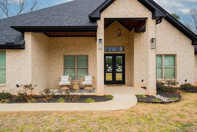 doorway to property featuring a lawn and french doors